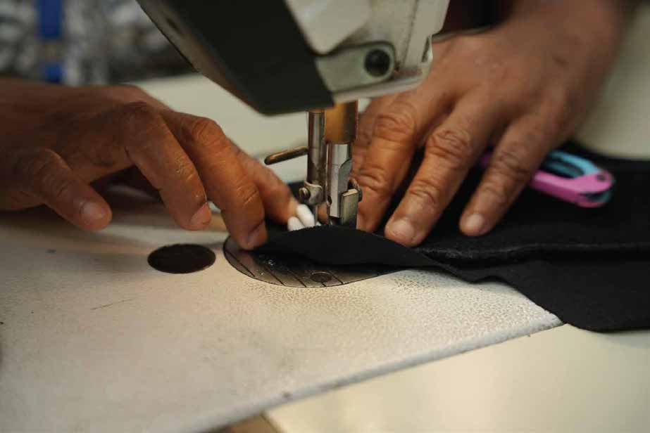 An Onivja machinist guiding fabric through a sewing machine